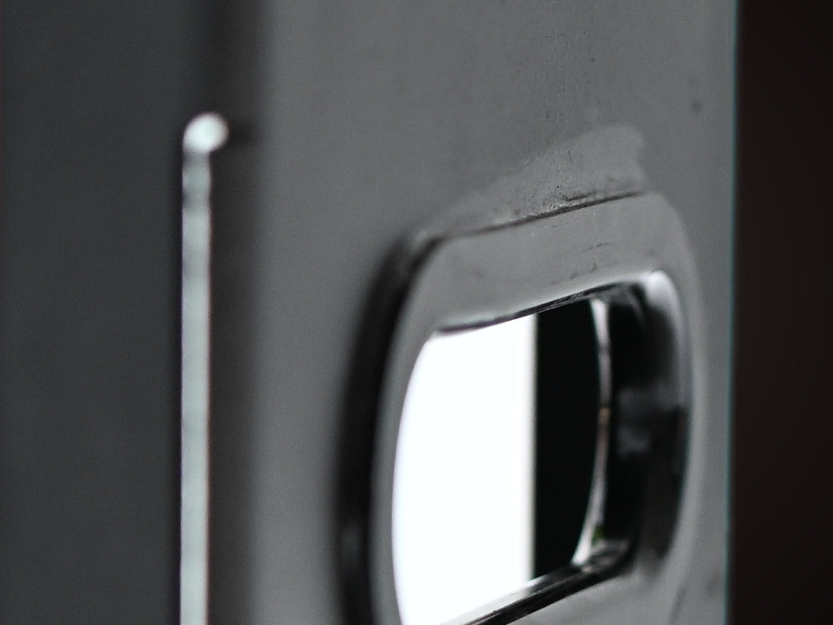 The molded end handle of an EmberBox, its chrome lip catching the light.